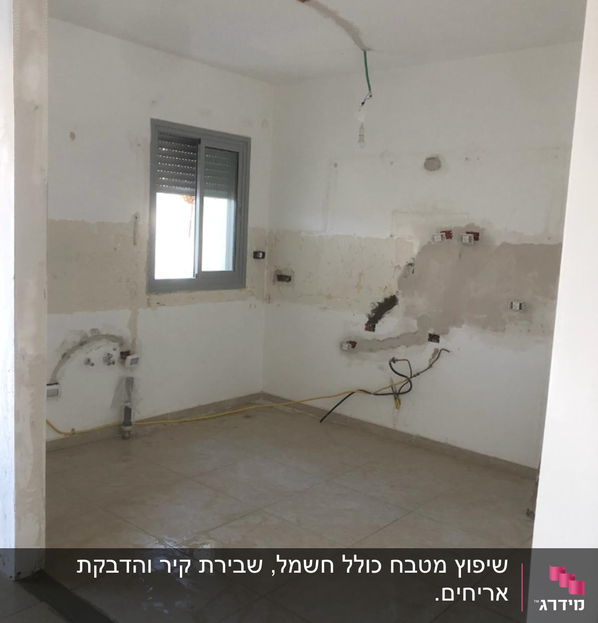 חדר בשיפוץ עם קירות חשופים וחוטי חשמל